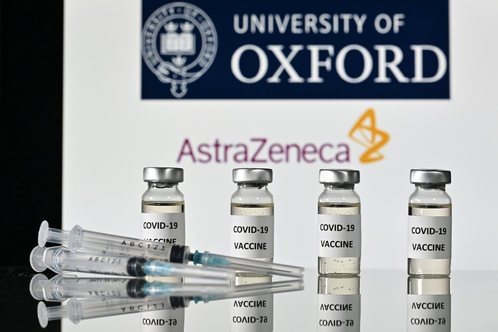 An illustration picture shows vials with Covid-19 Vaccine stickers attached and syringes, with the logo of the University of Oxford and its partner British pharmaceutical company AstraZeneca, on November 17, 2020. / AFP / JUSTIN TALLIS