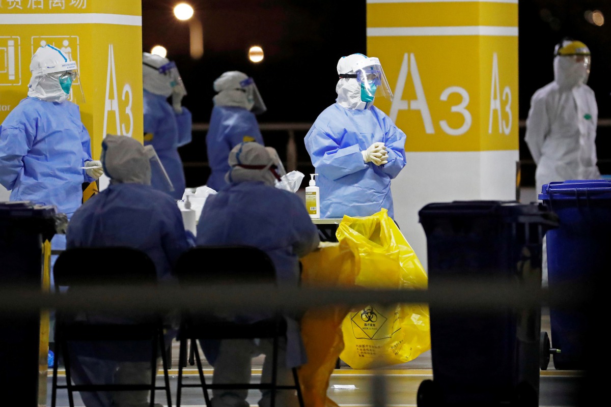 This photo taken on November 22, 2020 shows health workers in protective suits waiting to conduct COVID-19 coronavirus tests on staff at Pudong Airport in Shanghai. China OUT
/ AFP / CNS / STR