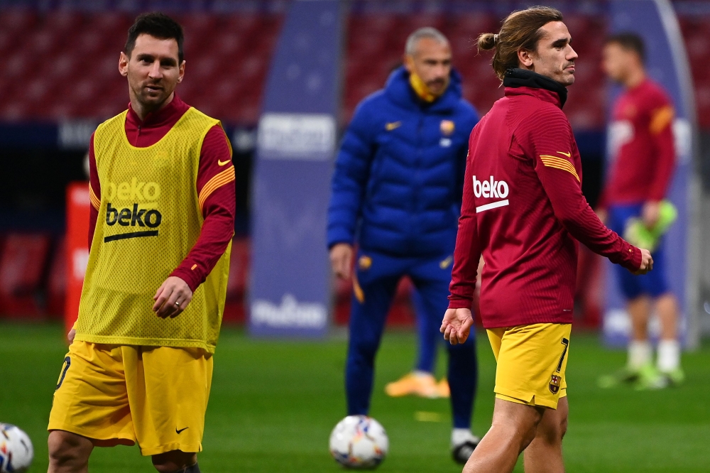 Barcelona's French midfielder Antoine Griezmann (R) and Barcelona's Argentine forward Lionel Messi warm up before the Spanish League football match between Club Atletico de Madrid and FC Barcelona at the Wanda Metropolitano stadium in Madrid on November 2