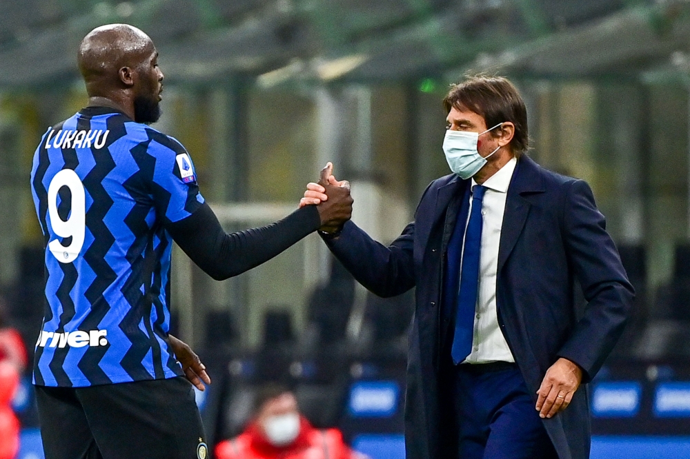 Inter Milan's Belgian forward Romelu Lukaku (L) and Inter Milan's Italian coach Antonio Conte tap hands at the end of the Italian Serie A football match Inter vs Torino on November 22, 2020 at the Giuseppe-Meazza (San Siro) stadium in Milan. / AFP / MIGUE