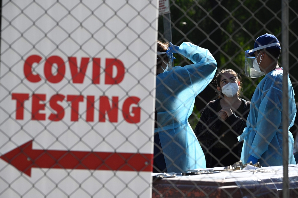 Healthcare workers are seen at a walk-up Covid-19 testing site, November 24, 2020, in San Fernando, California, just northeast of the city of Los Angeles. AFP / Robyn Beck