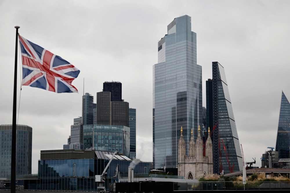 A Union Flag flutters in the wind near office buildings in the City of London in London on November 25, 2020. / AFP / Tolga Akmen
