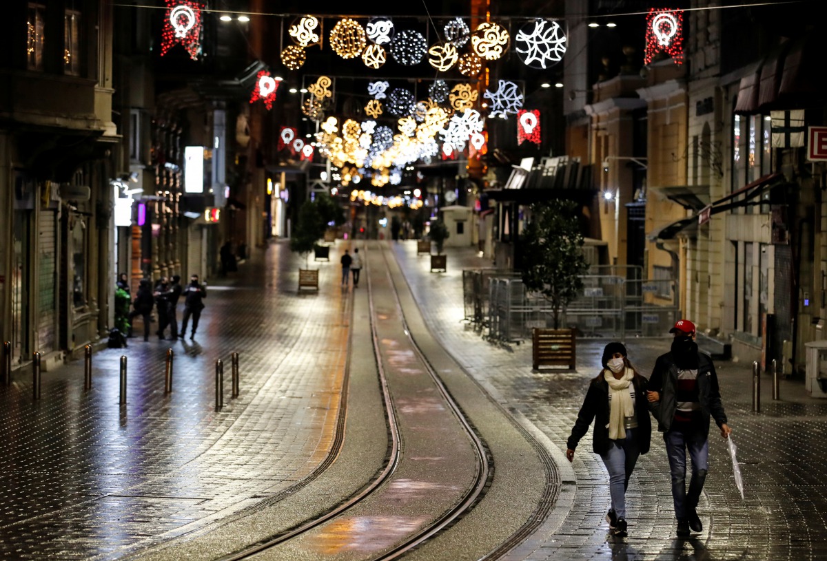 Couple walks along Istiklal Street at the popular touristic neighbourhood of Beyoglu after a partial weekend curfew started during the COVID-19 outbreak in Istanbul, Turkey, November 21, 2020. REUTERS/Umit Bektas
