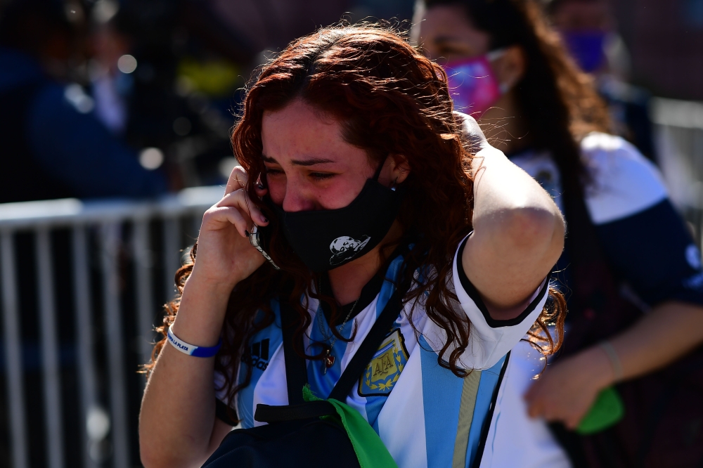 Diego Maradona's fans cry after paying their tribute to late football legend Diego Armando Maradona at the Government House in Buenos Aires, on November 26, 2020.   AFP / RONALDO SCHEMIDT