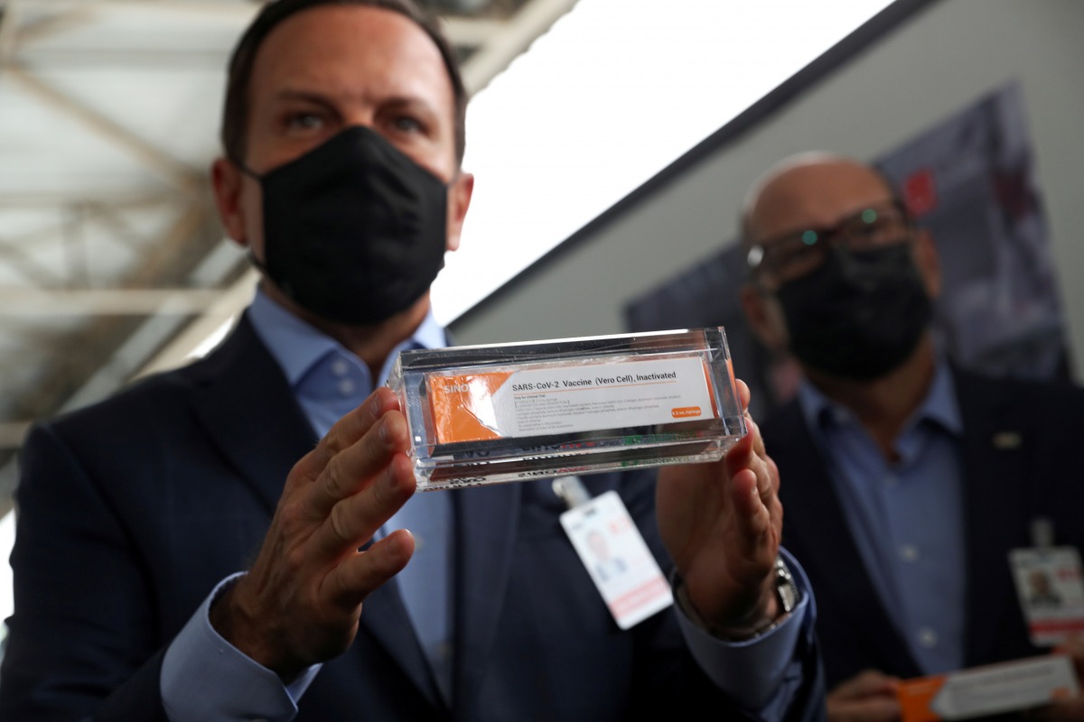 FILE PHOTO: Brazil's Sao Paulo state governor, Joao Doria, and director of Instituto Butantan, Dimas Tadeu Covas, hold boxes of the China's Sinovac vaccine against the coronavirus disease (COVID-19) as a cargo plane containing the vaccines arrives at Sao 