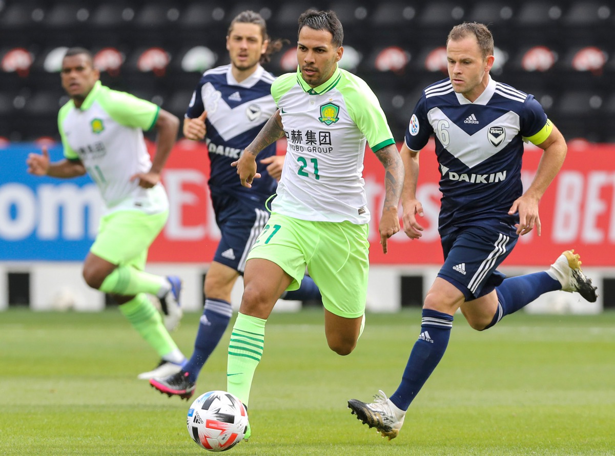 Beijing’s Jonathan Viera (centre) is marked by Melbourne’s midfielder Leigh Broxham (right) during their AFC Champions League group E match yesterday. 