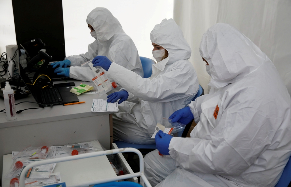 File photo: People wearing protective coverall work at the drive-thru testing centre on the coronavirus disease (COVID-19) in Warsaw, Poland, October 2, 2020. Reuters/Kacper Pempel/File Photo