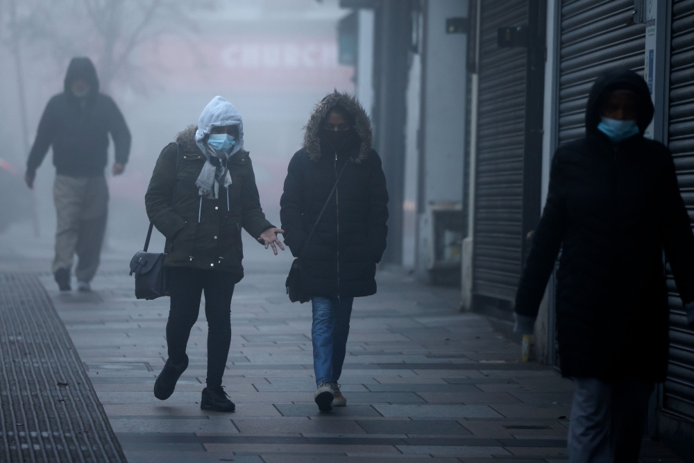 Pedestrians, some wearing a face mask or covering due to the COVID-19 pandemic, walk in the early morning fog in Walthamstow, east London on November 27, 2020. AFP / Tolga Akmen