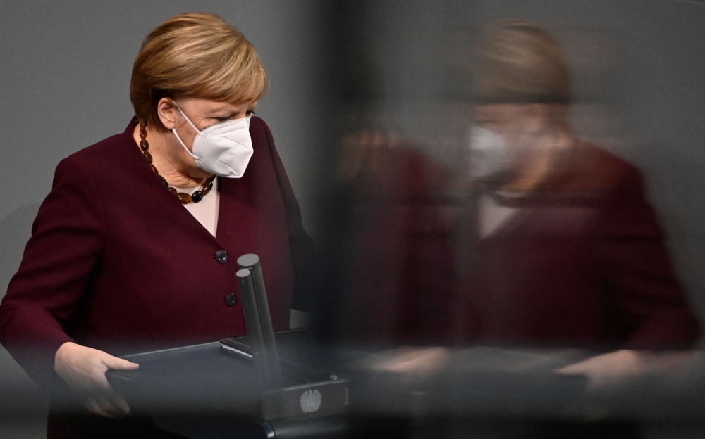 German Chancellor Angela Merkel is reflected as she wears a face mask before holding her speech during a session at the Bundestag (lower house of parliament) on November 26, 2020 in Berlin on measures to curb the spread of the novel coronavirus (COVID-19)