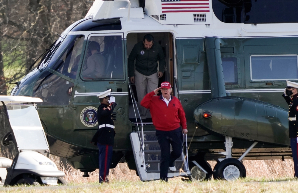 US President Donald Trump walks out of Marine One along with Donald Trump Jr, at Trump National Golf Club in Sterling, Virginia, U.S., November 28, 2020. REUTERS/Ken Cedeno