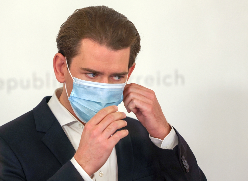 Austria's Chancellor Sebastian Kurz takes of his mask as he arrives to a news conference, as the spread of the coronavirus disease (COVID-19) continues, in Vienna, Austria November 25, 2020. REUTERS/Leonhard Foeger