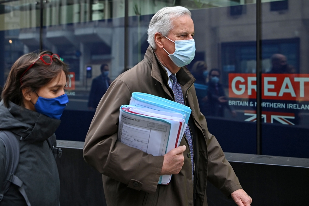 EU chief negotiator Michel Barnier wearing a protective face covering to combat the spread of the coronavirus, walks with his team to a conference centre to continue negotiations on a trade deal between the EU and the UK in London on November 29, 2020. AF
