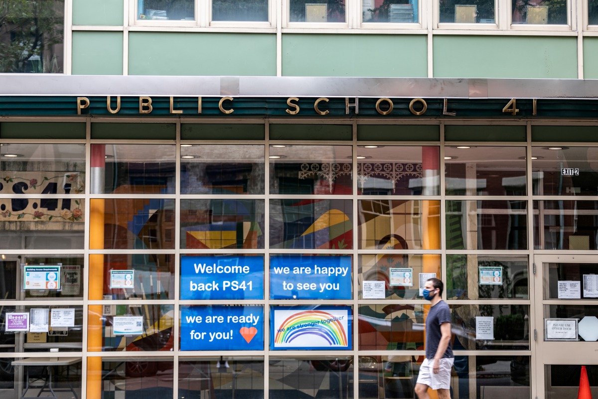 FILE PHOTO: A pedestrian walks past Public School 41 following the outbreak of the coronavirus disease (COVID-19) in the Manhattan borough of New York City, New York, U.S., September 27, 2020. REUTERS/Jeenah Moon/File Photo
