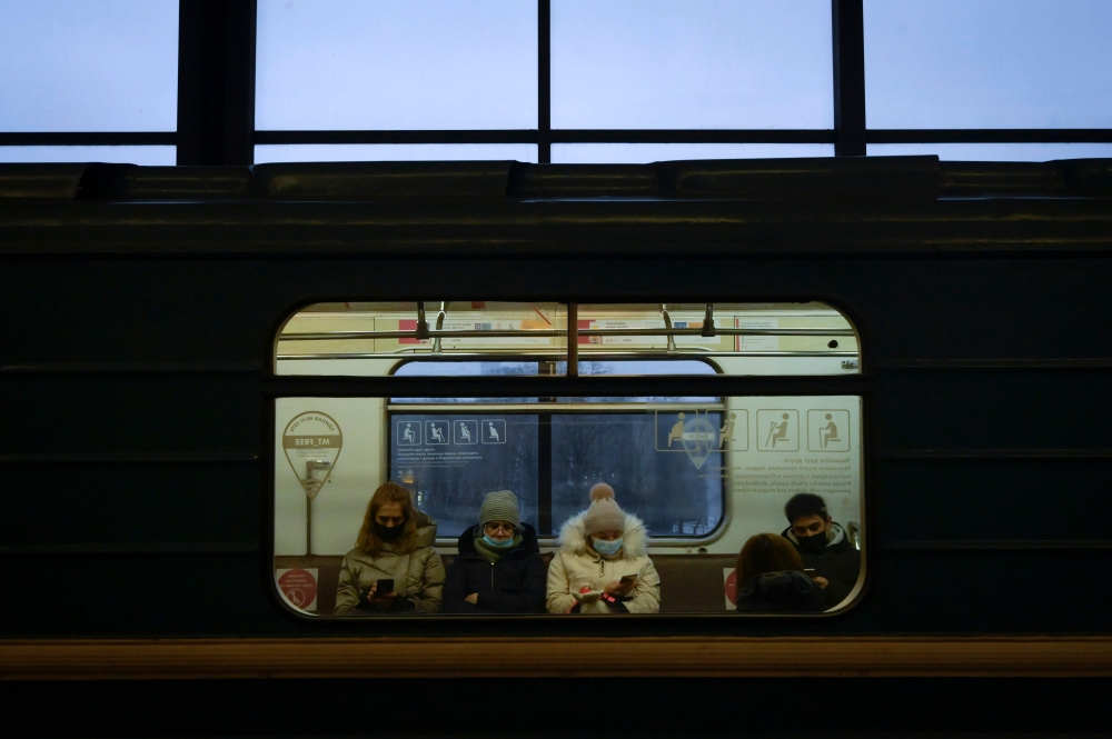 Passengers wearing face masks to protect against the coronavirus disease ride on a metro train in Moscow on November 30, 2020. / AFP / Natalia KOLESNIKOVA