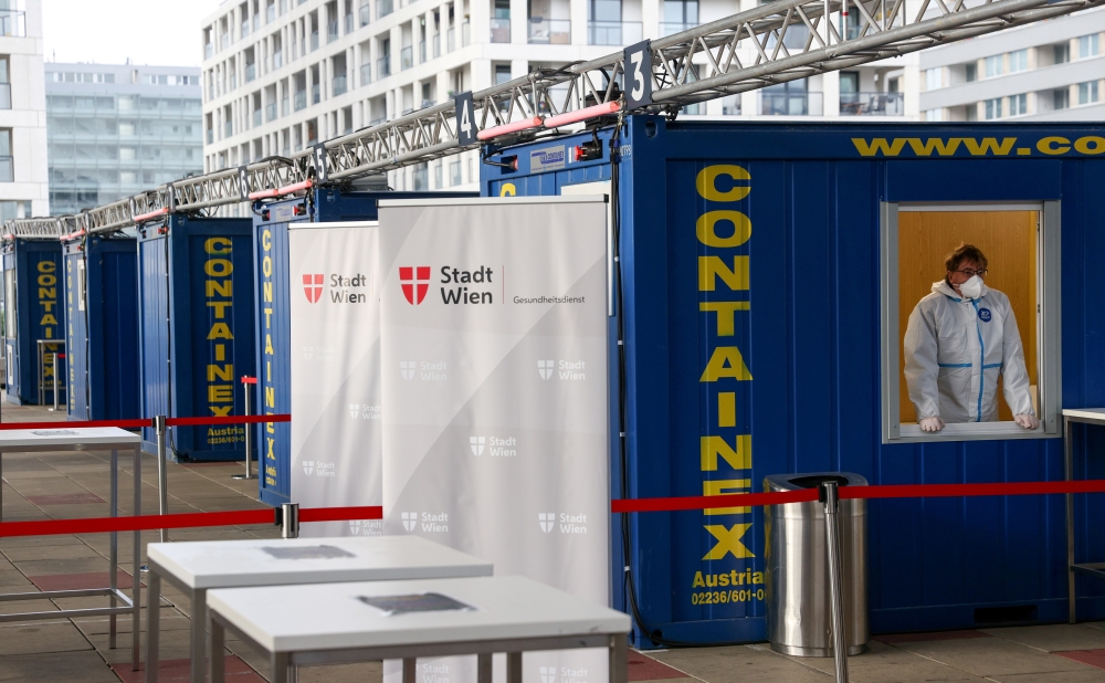 A healthcare worker wearing protective equipment is seen in a container as he waits for participants in rapid antigen testing at a mass testing station, as the spread of the coronavirus disease (COVID-19) continues, in Vienna, Austria November 30, 2020. R