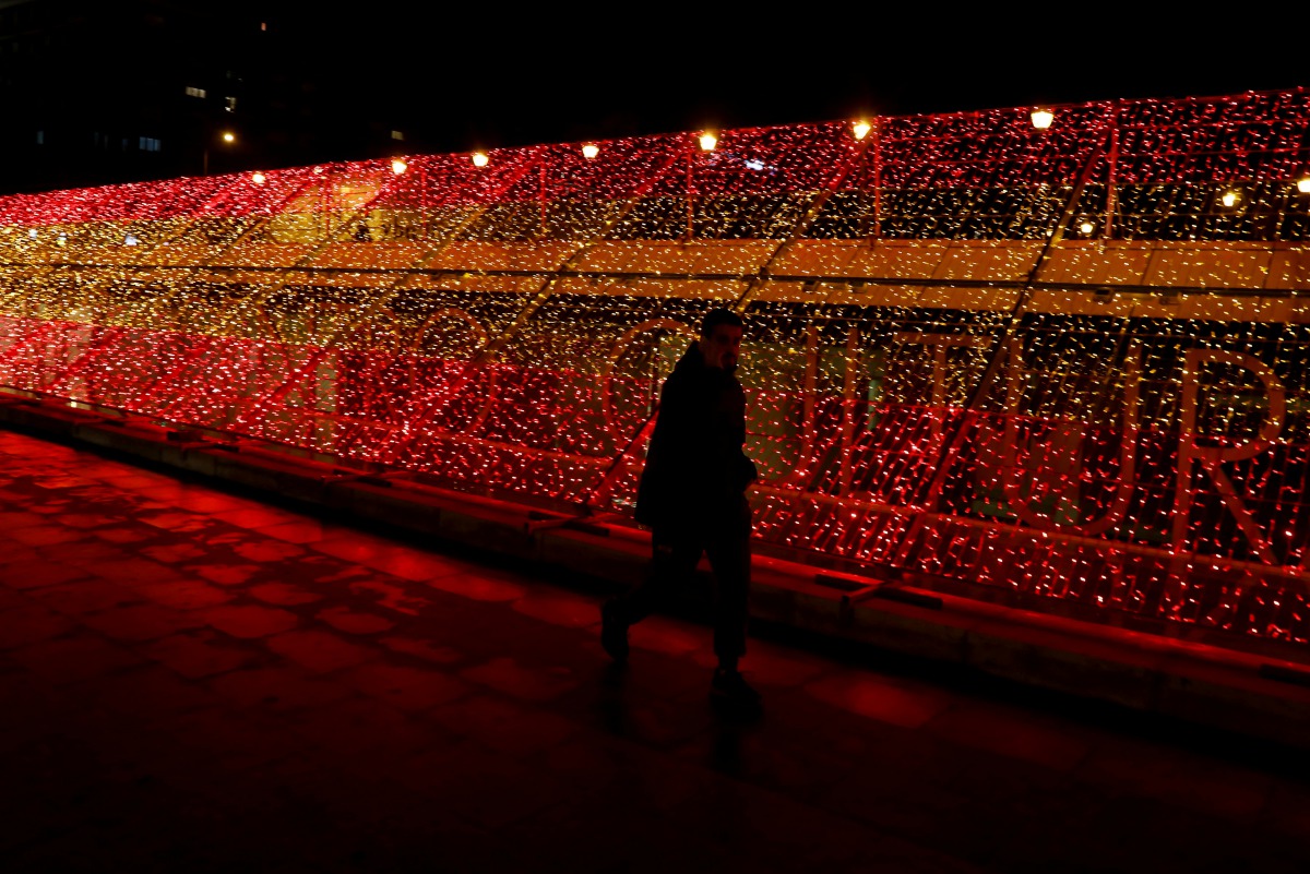 A man walks past a part of one kilometre-long Christmas illuminations with the colours of the Spanish flag, amid the coronavirus disease (COVID-19) outbreak in Madrid, Spain, November 26, 2020. REUTERS/Sergio Perez
