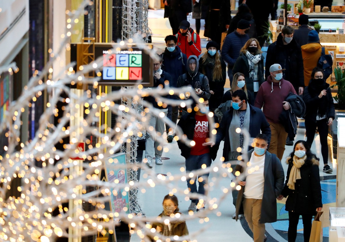 FILE PHOTO: People wear protective face masks as they walk beside Christmas decorations at a shopping mall amid the coronavirus disease (COVID-19) outbreak in Berlin, Germany, November 21, 2020. REUTERS/Fabrizio Bensch/File Photo
