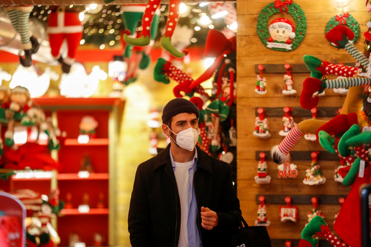 A man wearing a protective mask looks on inside a shop on the day Italian Health Minister Roberto Speranza lays out in parliament the government's plan for mass coronavirus disease (COVID-19) vaccinations and restrictions over the Christmas period, in Rom