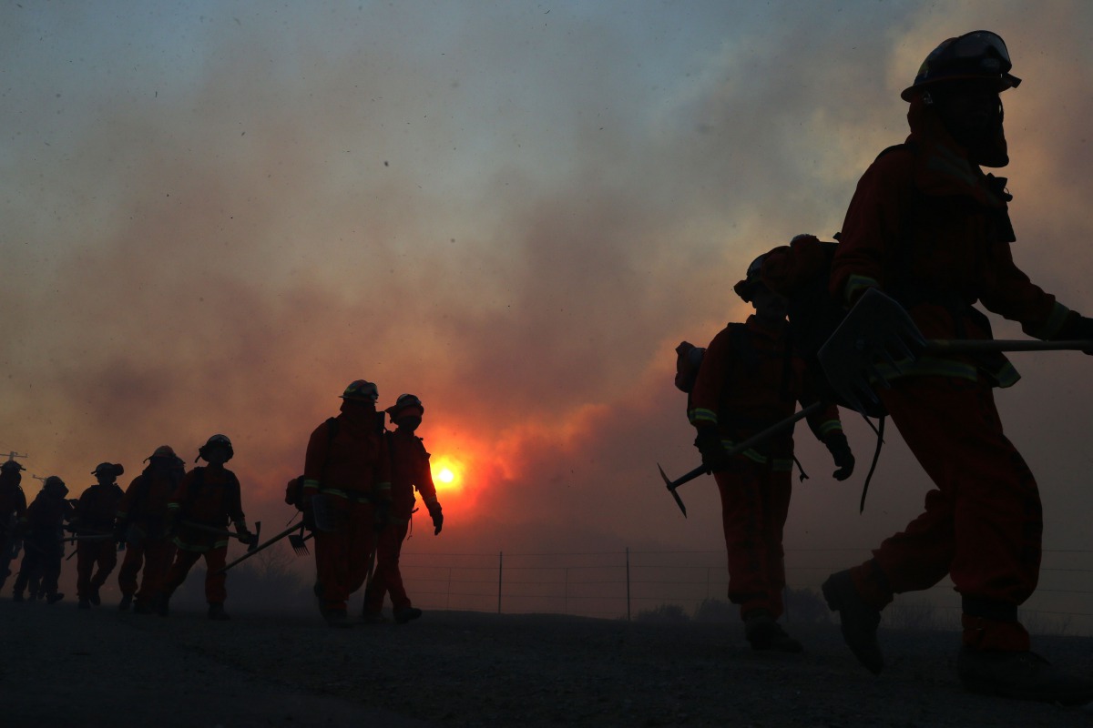 IRVINE CALIFORNIA - DECEMBER 03: Inmate firefighters work as the Bond Fire burns shortly after sunrise in the Silverado Canyon area of Orange County on December 3, 2020 near Irvine, California. The 4,000-acre wildfire broke out along with a number of othe