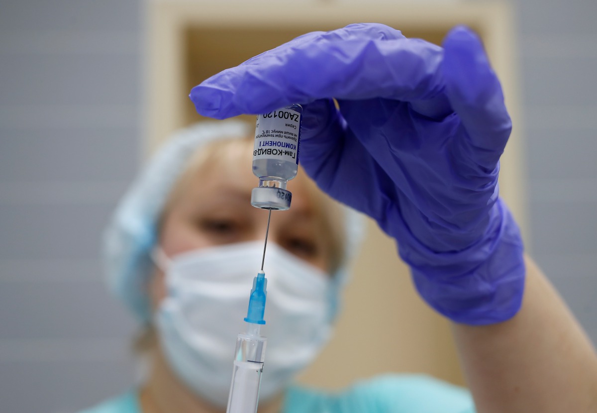 A medical worker fills a syringe with Sputnik V (Gam-COVID-Vac) vaccine before administering an injection during the vaccination against the coronavirus disease (COVID-19) at a clinic in the town of Domodedovo near Moscow, Russia December 3, 2020. REUTERS