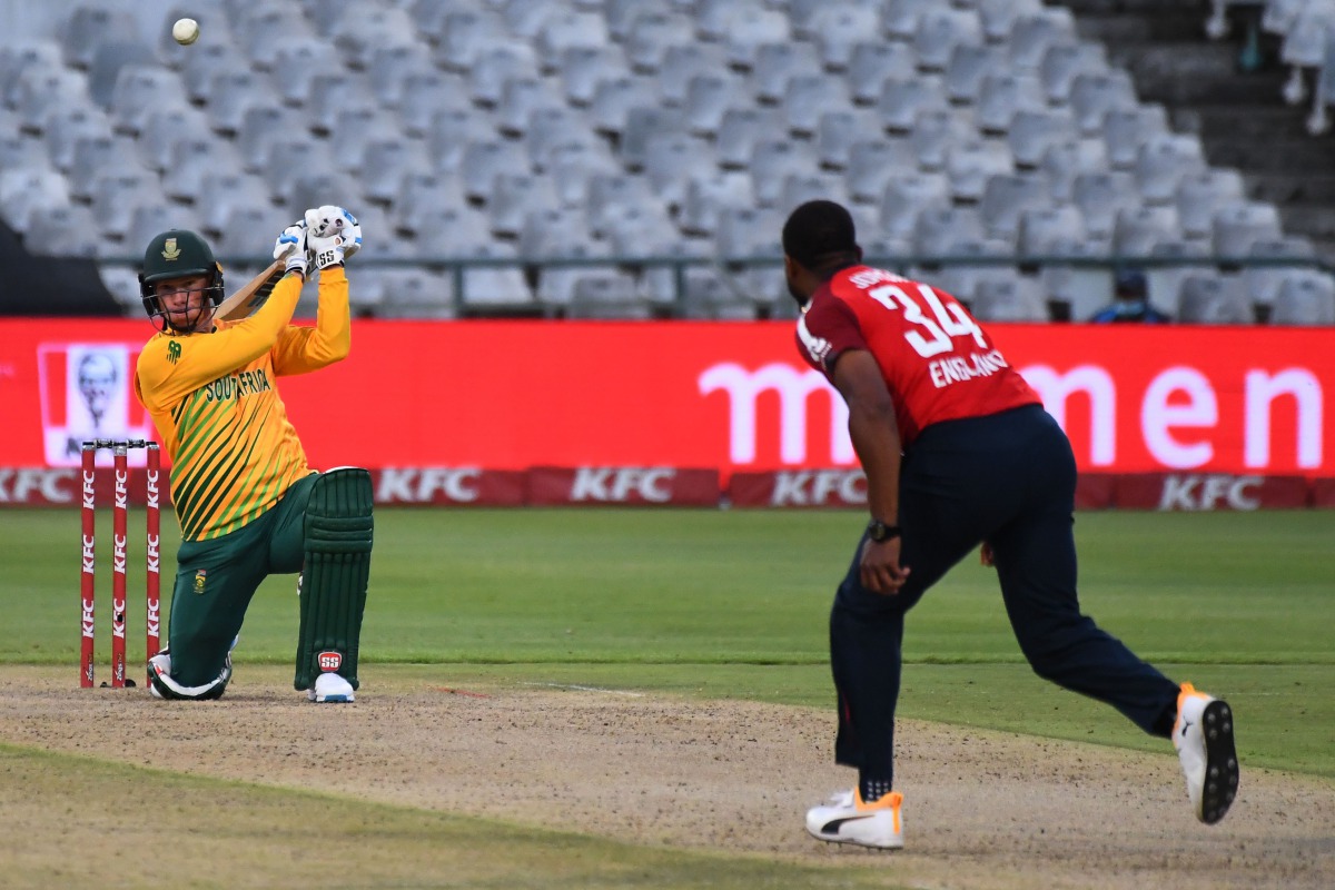 South Africa's Rassie van der Dussen (L) watches the ball after playing a shot delivered by England's Chris Jordan (R) during the third T20 international cricket match between South Africa and England at Newlands stadium in Cape Town, South Africa, on Dec