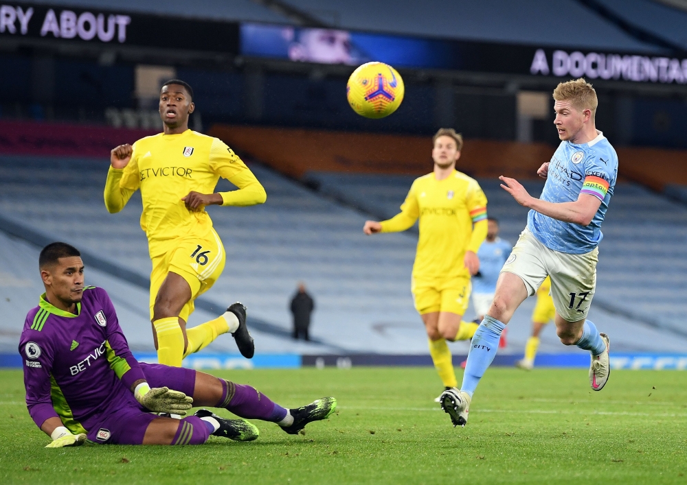 Manchester City's Belgian midfielder Kevin De Bruyne (R) has a shot saved by Fulham's French goalkeeper Alphonse Areola during the English Premier League football match between Manchester City and Fulham at the Etihad Stadium in Manchester, north west Eng