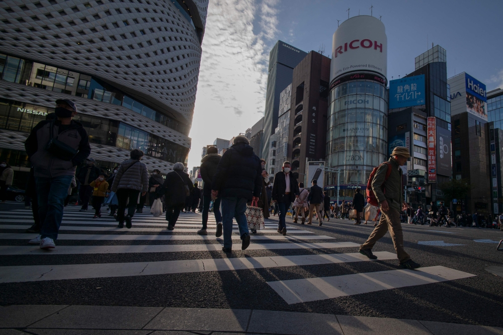 People cross a street in the Ginza shopping district in Tokyo on December 6, 2020. / AFP / Kazuhiro Nogi