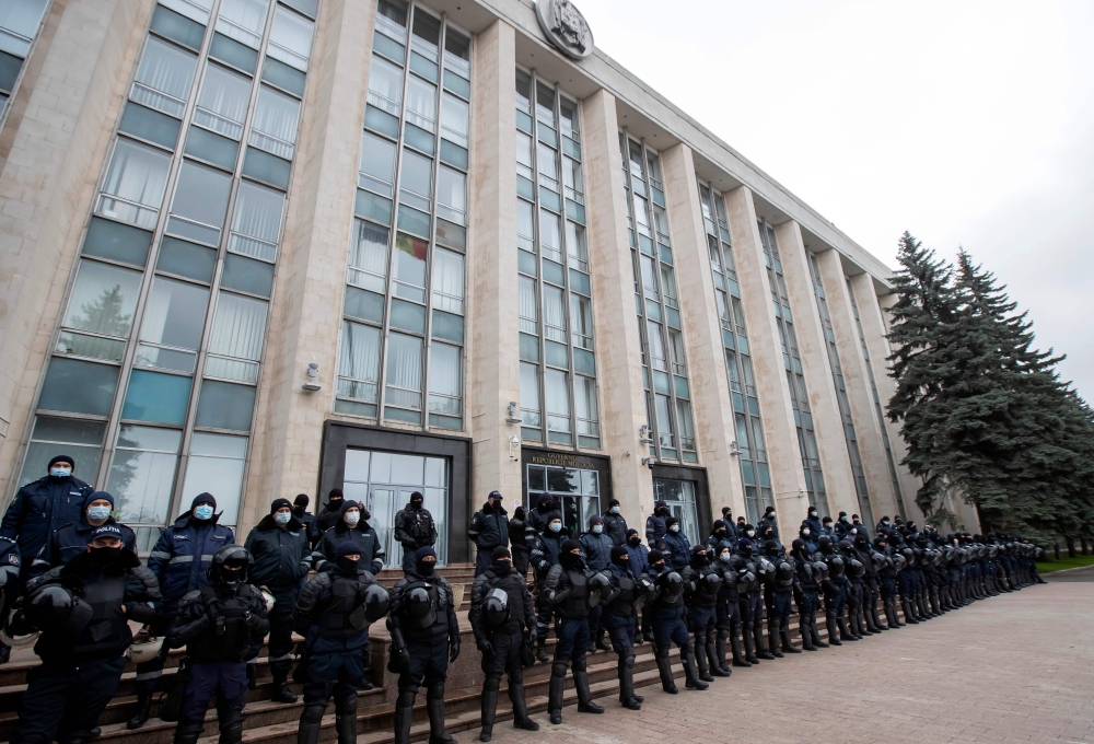 Riot police forces stand guard in front of the government building during a rally to demand the government's resignation and snap parliamentary elections on December 6, 2020 in central Chisinau. AFP / Bogdan TUDOR
