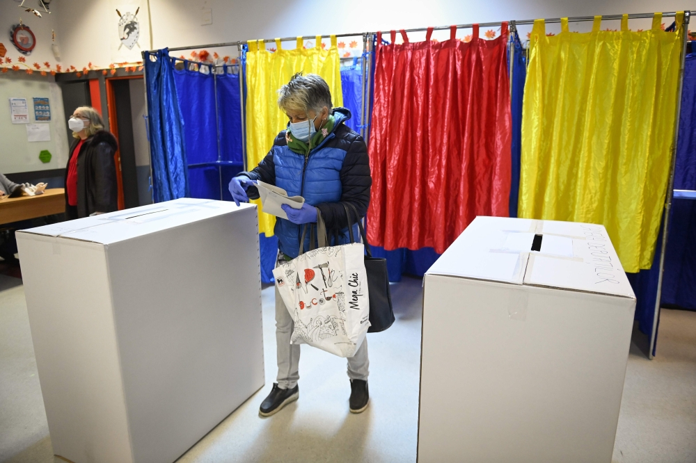 A woman votes at a polling station in Bucharest during the parliamentary elections on December 6, 2020.  AFP / Daniel MIHAILESCU