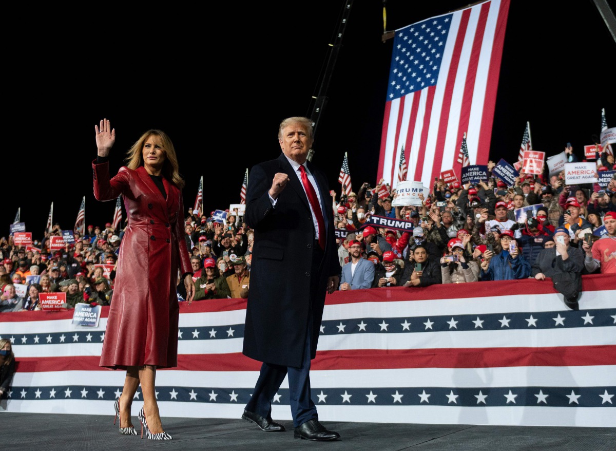 US President Donald Trump leaves the stage with First Lady Melania Trump at the end of a rally to support Republican Senate candidates at Valdosta Regional Airport in Valdosta, Georgia on December 5, 2020. / AFP / ANDREW CABALLERO-REYNOLDS
