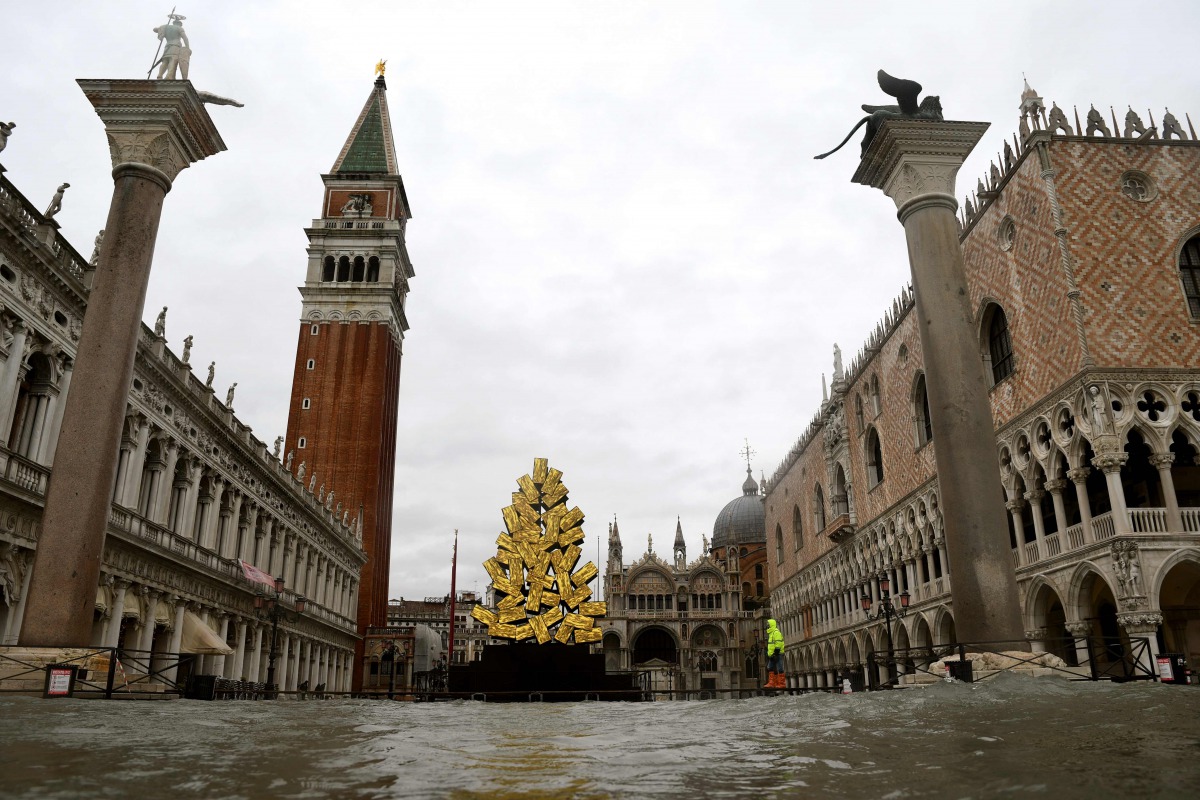 A view shows a flooded St. Mark's Square with the Doge's Palace (R), the Bell Tower (Rear L), St. Mark's Basilica (Rear C) and a luminous Christmas Tree installation by Italian artist Fabrizio Plessi (Front C) on December 8, 2020 following a high tide 