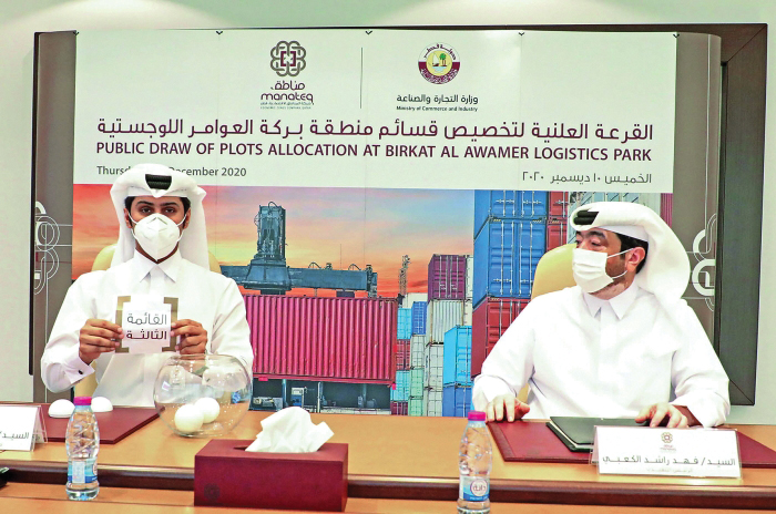 Eng. Fahad Rashid Al Kaabi (right), CEO of Manateq looks on, while a senior official from the Ministry of Commerce and Industry showing one of the winners of a land plot for Birkat Al Awamer Logistics Park, yesterday. 
