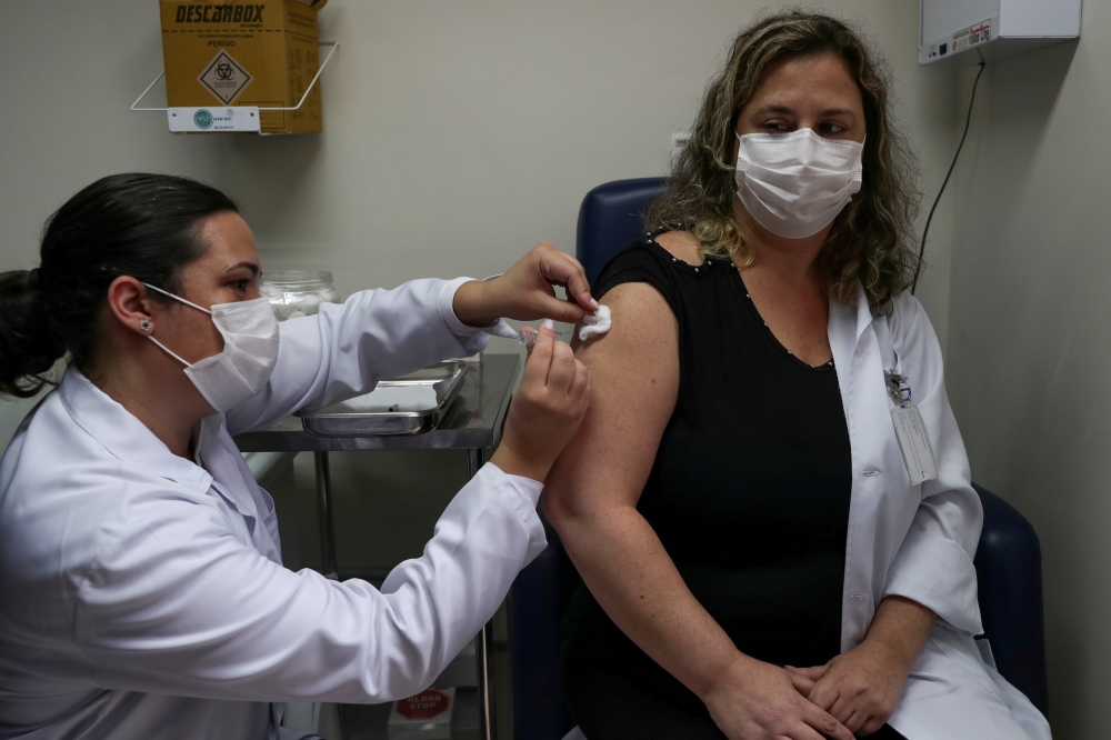 A nurse administers CoronaVac, a Sinovac's potential vaccine against the coronavirus disease (COVID-19), to a volunteer and nurse Sarah Rangon at Emilio Ribas Institute in Sao Paulo, Brazil July 30, 2020. Picture taken July 30, 2020. REUTERS/Amanda Perobe