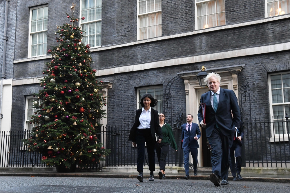 Britain's Prime Minister Boris Johnson (R) leaves 10 Downing Street in London on December 15, 2020 with Director of the Number 10 Policy Unit Munira Mirza (L) to attend the weekly cabinet meeting held at the nearby Foreign, Commonwealth and Development Of