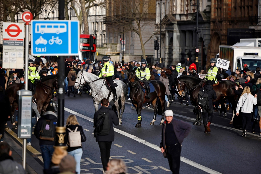 Mounted police officers attempt to prevent protesters march up Whitehall after they gather in Parliament Square at an anti-lockdown demonstration, 