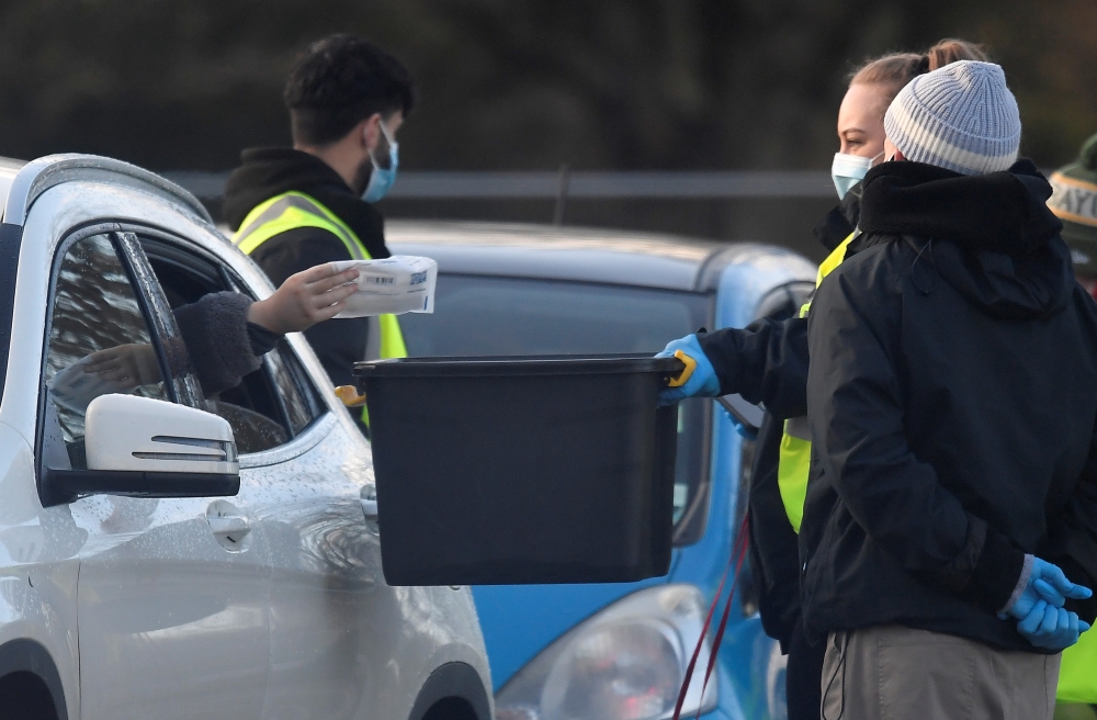 Officials collect Coronavirus COVID-19 testing samples at a drive-through test centre amid the spread of the coronavirus disease (COVID-19) in London, Britain, December 19, 2020. REUTERS/Toby Melville
