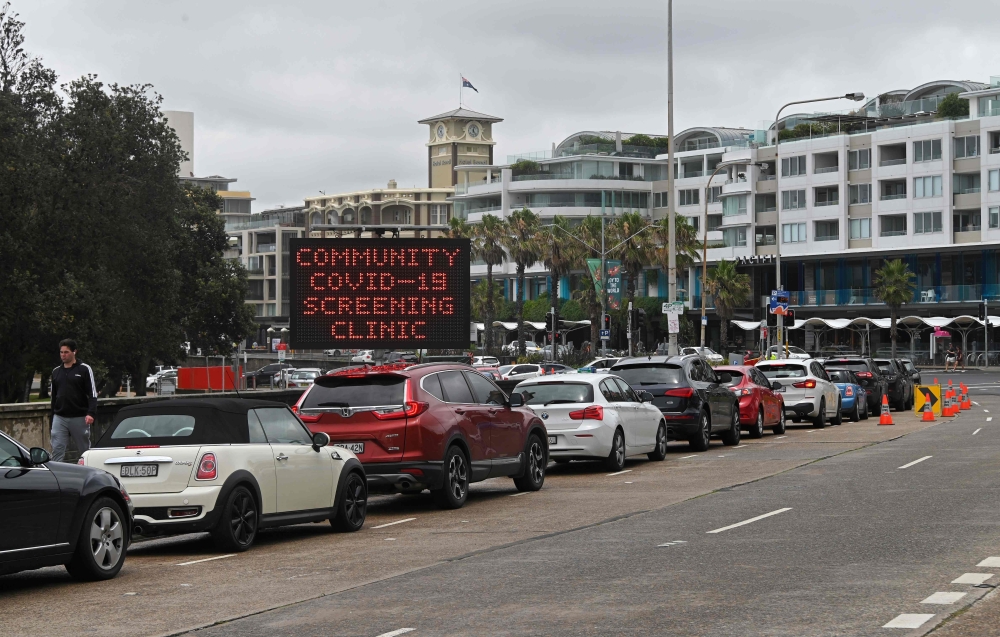 People queue in cars at a Covid-19 drive-through testing centre at Bondi Beach in Sydney on December 20, 2020. / AFP / Steven Saphore
