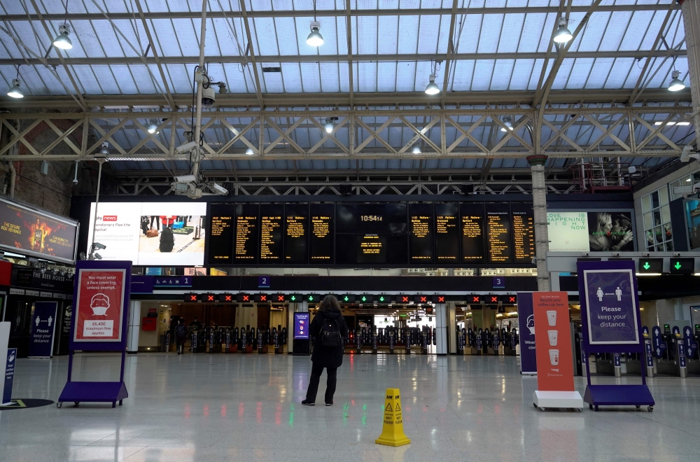 A traveller looks at train departure boards in an almost deserted concourse at Charing Cross train station in London on December 20, 2020. AFP / Niklas HALLE'N