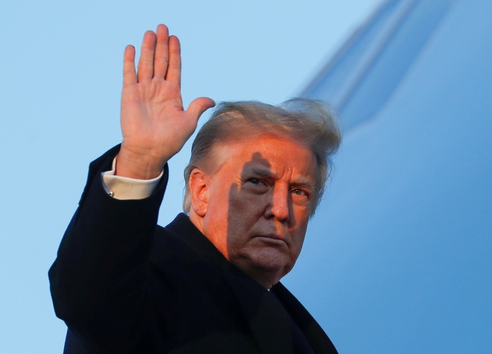 US President Donald Trump waves as he boards Air Force One at Joint Base Andrews in Maryland, US, December 23, 2020. Reuters/Tom Brenner 