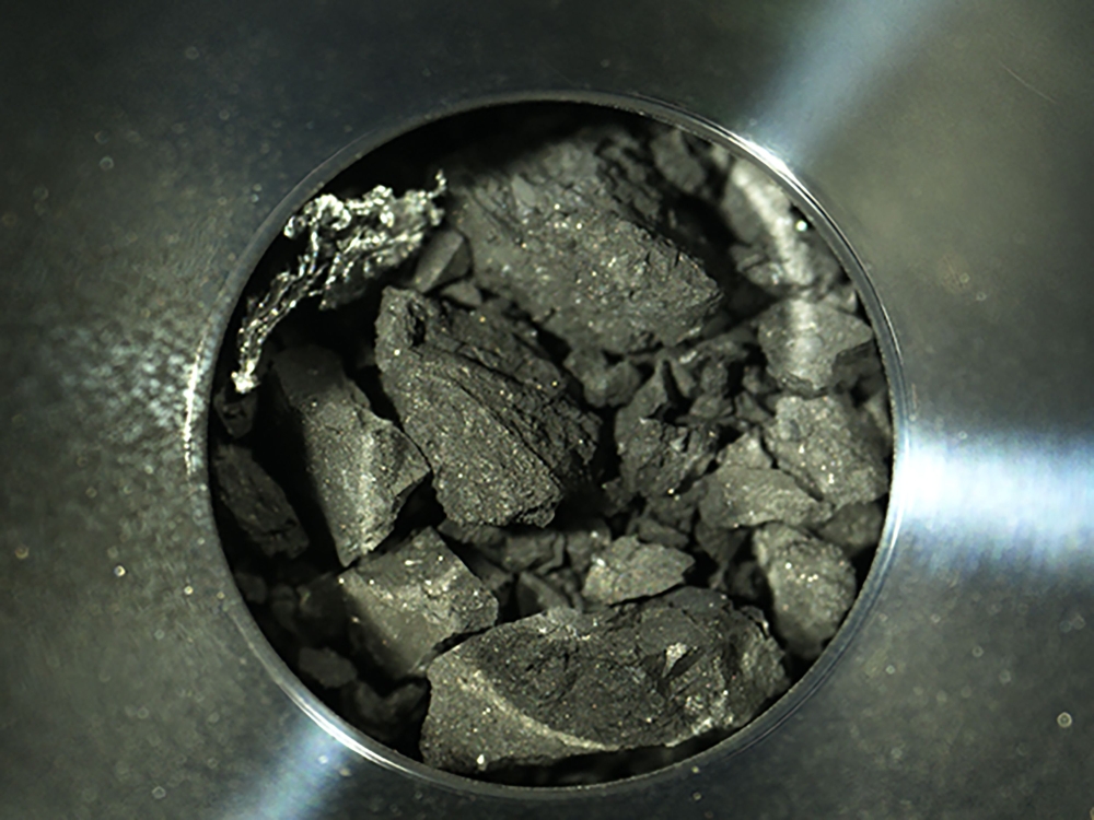 This handout photograph released by the Japan Aerospace Exploration Agency (JAXA) on December 24, 2020 shows samples of soil from the asteroid Ryugu, inside C compartment of the capsule collected by the Hayabusa-2 space probe, at JAXA Sagamihara Campus in