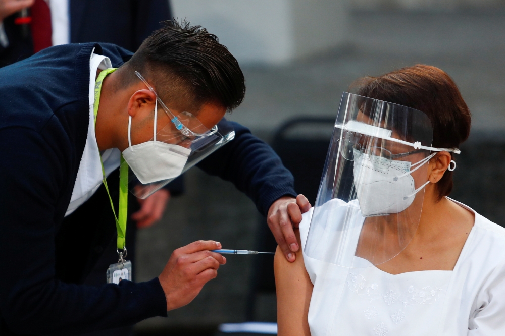 Maria Irene Ramirez receives the first injection with a dose of the Pfizer/BioNtech COVID-19 vaccine at General Hospital, as the coronavirus disease (COVID-19) outbreak continues, in Mexico City, Mexico December 24, 2020. REUTERS/Edgard Garrido
