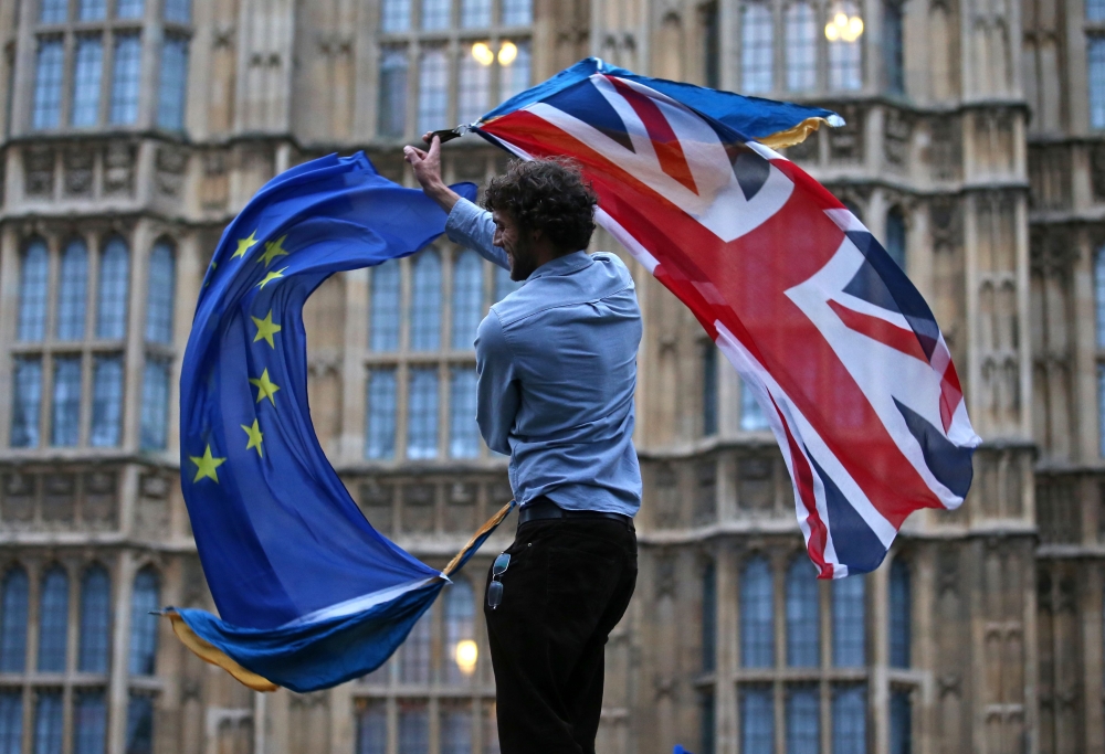 In this file photo taken on June 28, 2016 a man waves both a Union flag and a European flag together on College Green outside The Houses of Parliament at an anti-Brexit protest in central London. (AFP / JUSTIN TALLIS)
