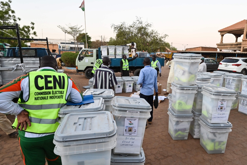 Members of Niger's Independent National Electoral Commission (CENI) load ballot boxes and election equipment onto a truck on December 26, 2020, in Niamey, on the eve of the country's presidential and legislative elections. / AFP / Issouf SANOGO