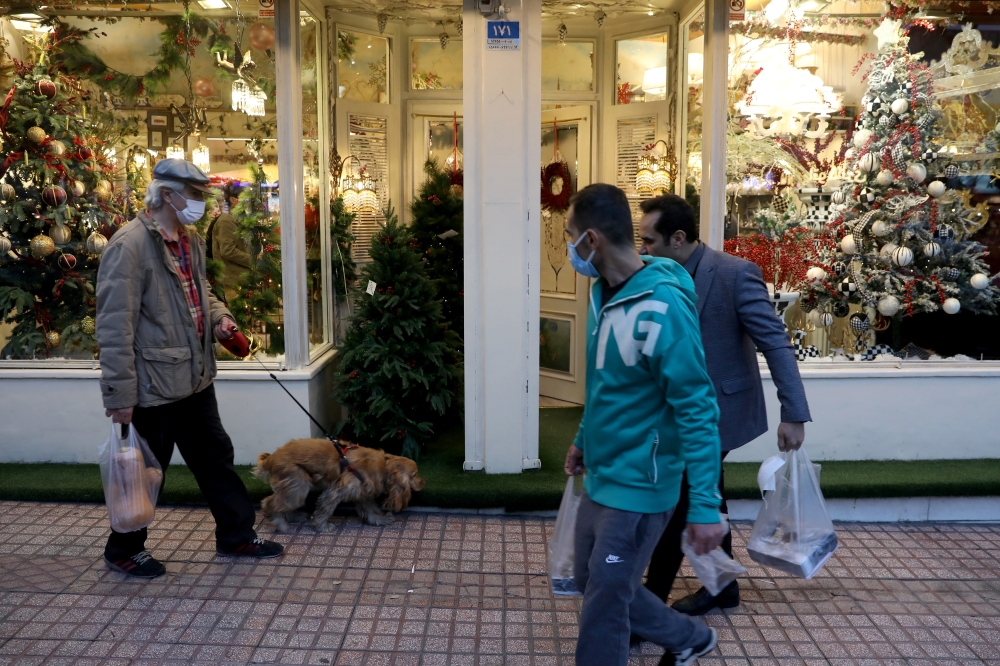 Iranian people walk past a Showcase of a Christmas store in Tehran, Iran December 23, 2020. Picture taken December 23, 2020. Majid Asgaripour