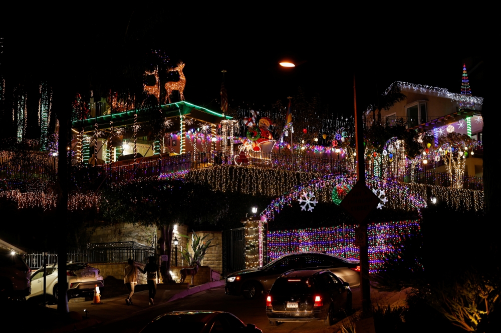 People drive by a house decorated with Christmas lights during the outbreak of the coronavirus disease (COVID-19), in the Hastings Ranch area of Pasadena, California, U.S., December 22, 2020. Picture taken December 22, 2020. REUTERS/Mario Anzuoni
