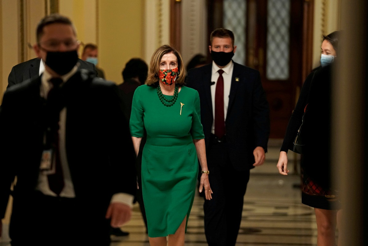 FILE PHOTO: Speaker of the House Nancy Pelosi (D-CA), walks from the Senate floor as both chambers of Congress are aimed to pass the coronavirus disease (COVID-19) package in a marathon session on Capitol Hill Washington, D.C., U.S., December 21, 2020. RE