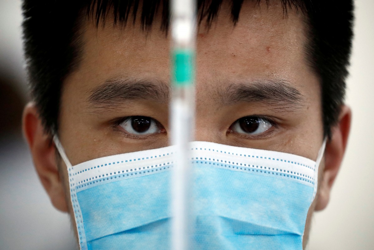 FILE PHOTO: A man works in a laboratory of Chinese vaccine maker Sinovac Biotech, developing an experimental coronavirus disease (COVID-19) vaccine, during a government-organized media tour in Beijing, China, Sept. 24, 2020. REUTERS/Thomas Peter/File Phot