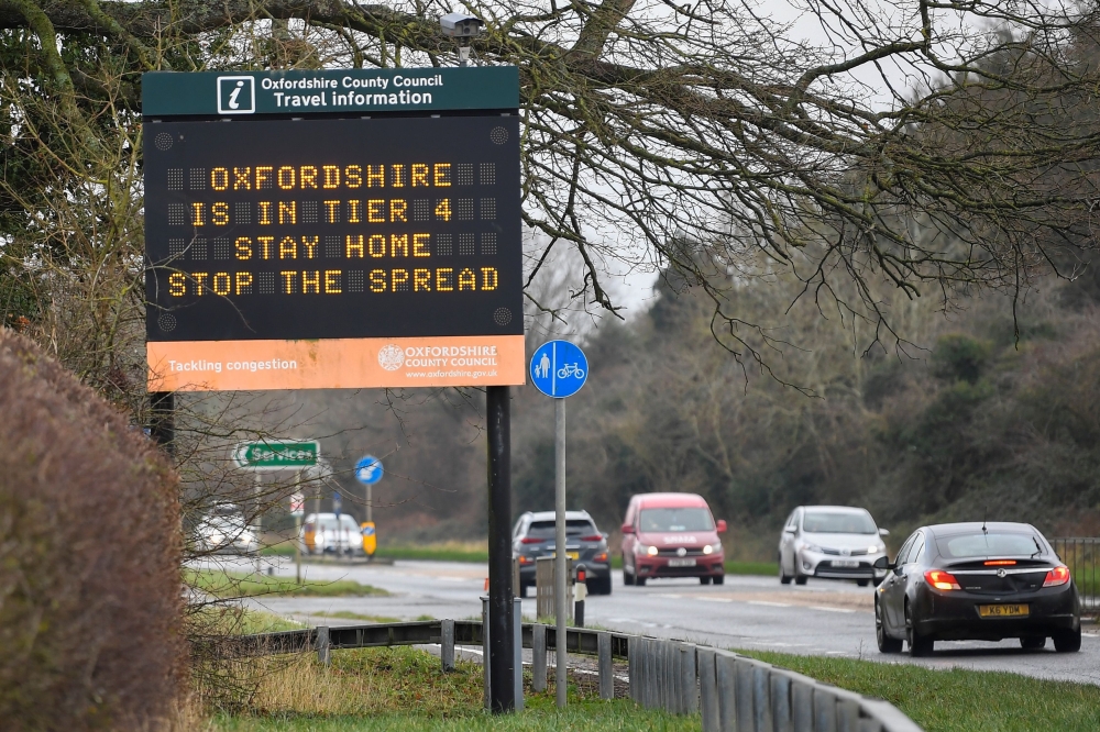 Vehicles drive past a roadside public health information sign, amidst the spread of the coronavirus disease (COVID-19) pandemic, near Oxford, Britain, December 28, 2020. REUTERS/Toby Melville