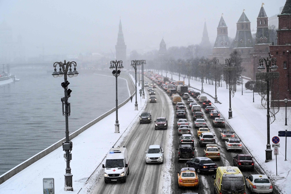 Cars are seen stuck in a traffic jam on an embankment of the Moskva river outside the Kremlin during a heavy snowfall in Moscow on December 25, 2020. / AFP / Kirill KUDRYAVTSEV
