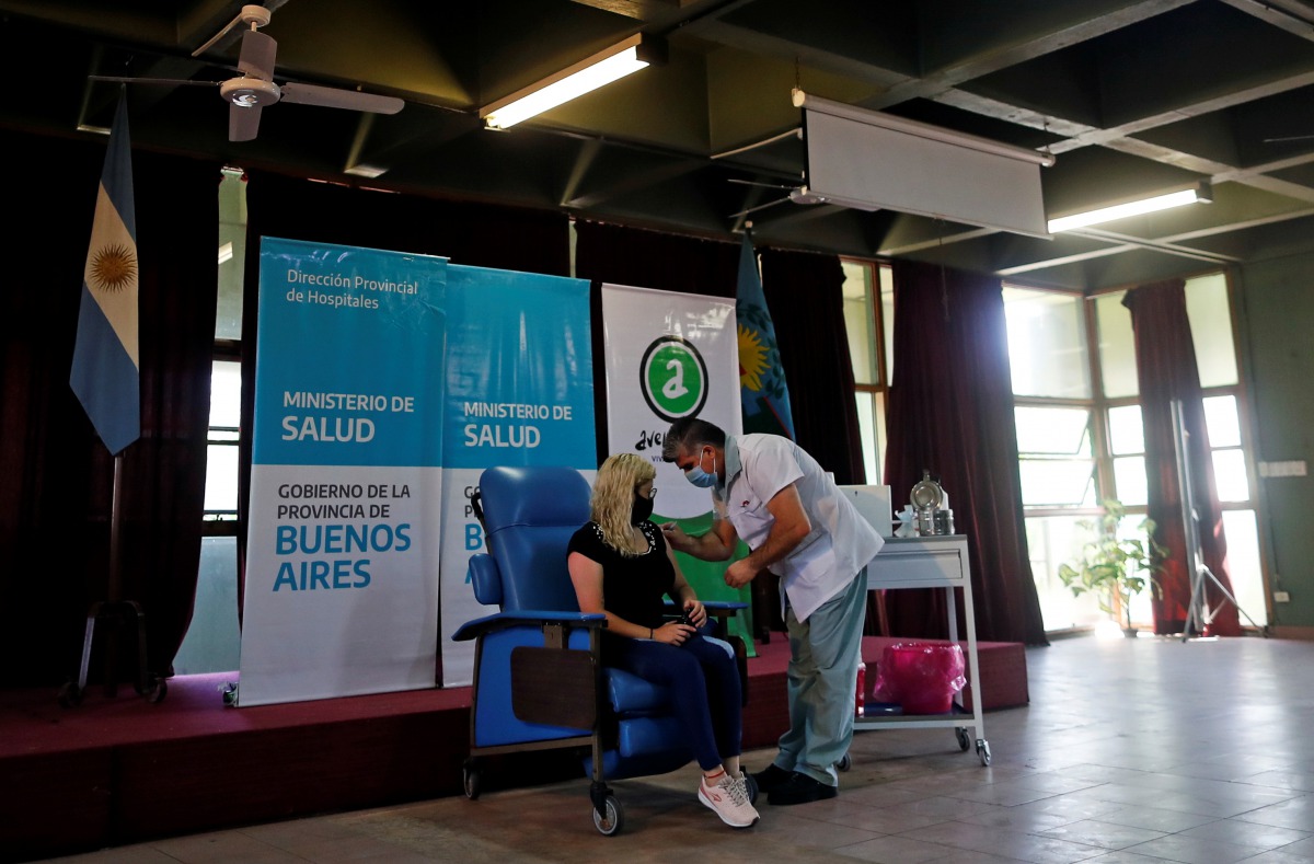 A woman receives an injection with the Sputnik V (Gam-COVID-Vac) vaccine against the coronavirus disease (COVID-19) at Dr. Pedro Fiorito hospital in Avellaneda, on the outskirts of Buenos Aires, Argentina, December 29, 2020. REUTERS/Agustin Marcarian

